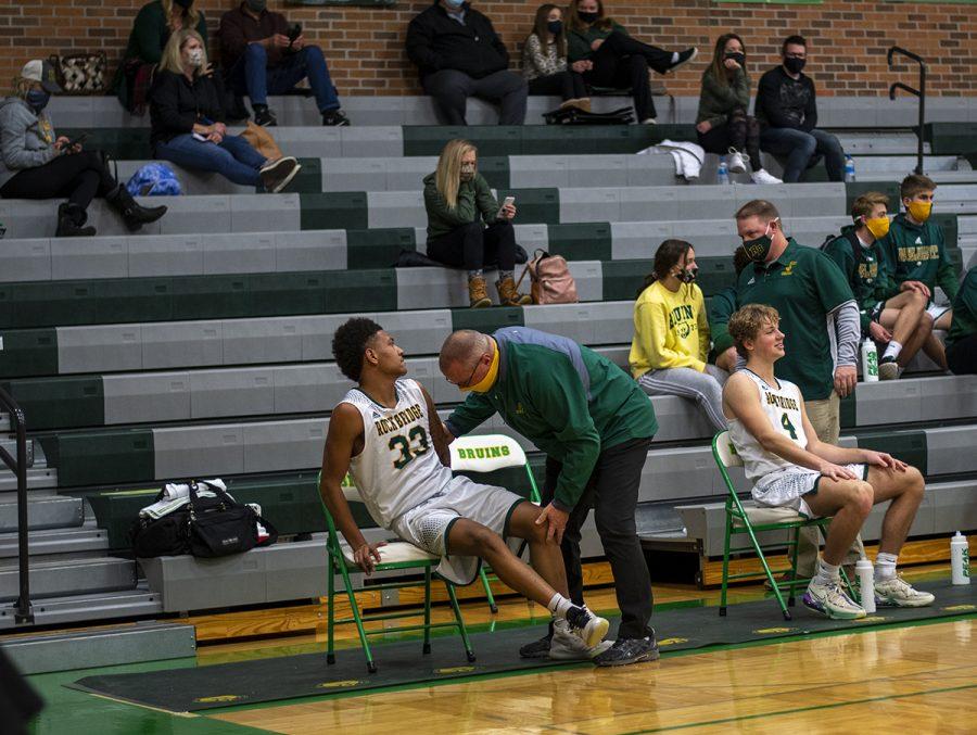 Senior+forward+Carlos+Brown+sits+on+the+bench%2C+while+a+medic+inspects+his+ankle.+Brown+sustained+an+injury+in+the+last+quarter%2C+and+had+to+sit+out+the+rest+of+the+game+on+Tuesday%2C+Jan.+5.+Photo+by+Ana+Manzano.