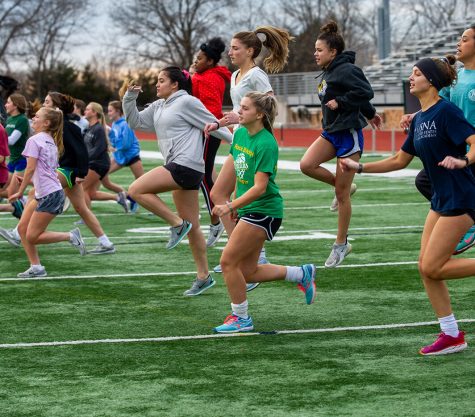 The girls soccer team does skips at tryouts Monday, March 2. The team did basic stretches before going on their run. Photo by Ana Manzano.