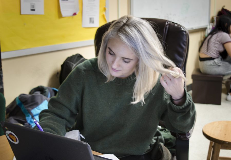Junior Quinn Tyler fidgets with her hair while working on homework, one way she reduces anxiety from classwork and school pressures. Photo by Ana Manzano.