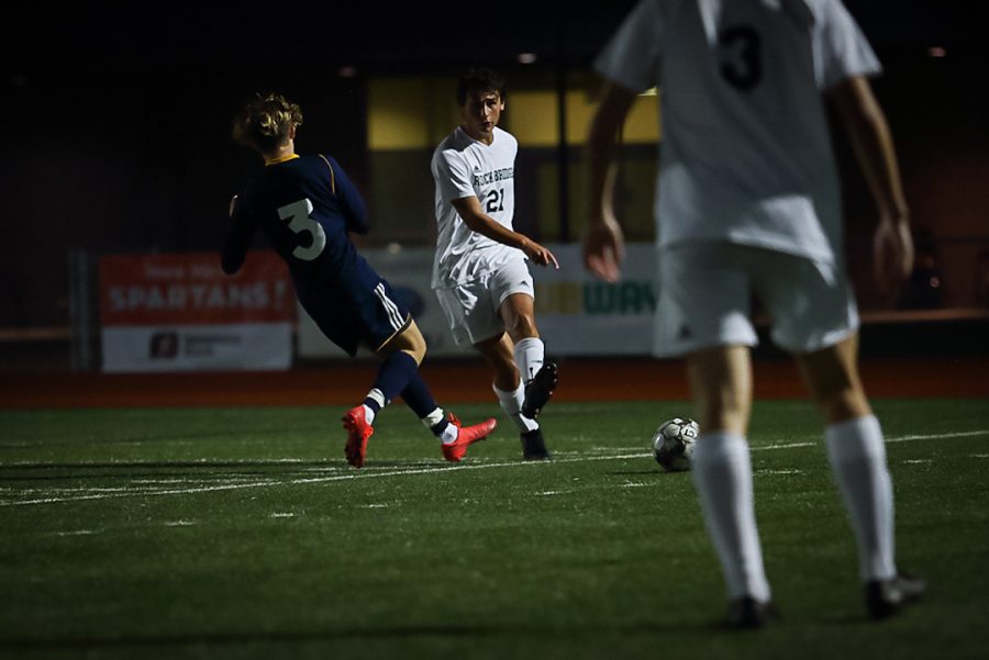 Junior Andrew Copeland passes the ball to his teammate in the boys varsity soccer game against Battle High School Tuesday, Oct. 13. Photo by Desmond Kisida.