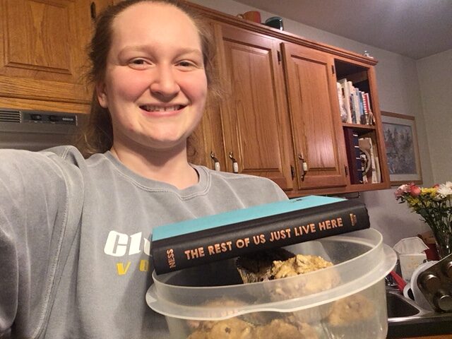 Bailey Stover holds her muffins and book in her kitchen on the fourth day of quarantine. Photo by Bailey Stover.