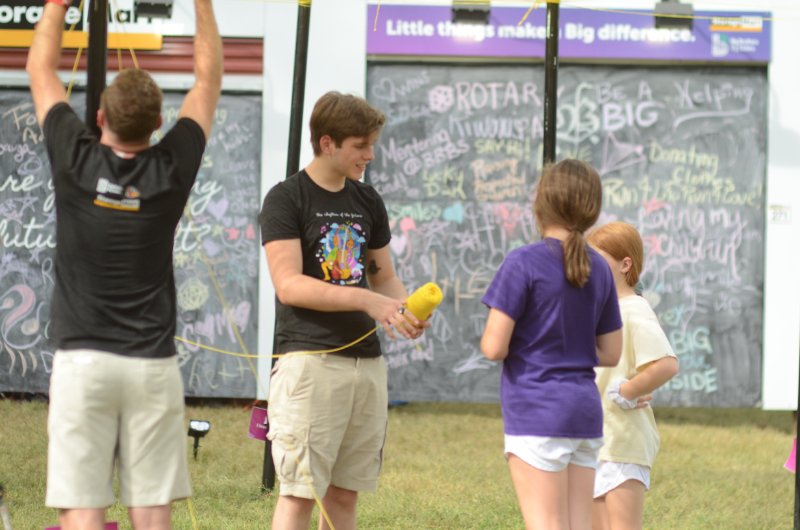 Junior Blake Bodendieck, a Unity project volunteer, works with Coreina and Camryn Fullerton Saturday, Sept. 28 at the Roots N Blues festival. Photo by Bailey Stover.