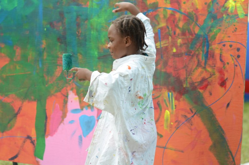 A+child+participates+in+one+of+Wildy+Selfs+collaborative+murals+during+Roots+N+Blues+Saturday%2C+Sept.+28.+Photo+by+Bailey+Stover.