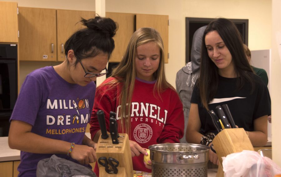 International Cultural Organization members junior Aleena Li, sophomore Grace Schondelmuyer, and senior Beatrice Rotondi peel potatoes. The potatoes had to be sliced and peel so they could be easily grilled. The club ate and prepared biryani, a traditional Iraqui dish.