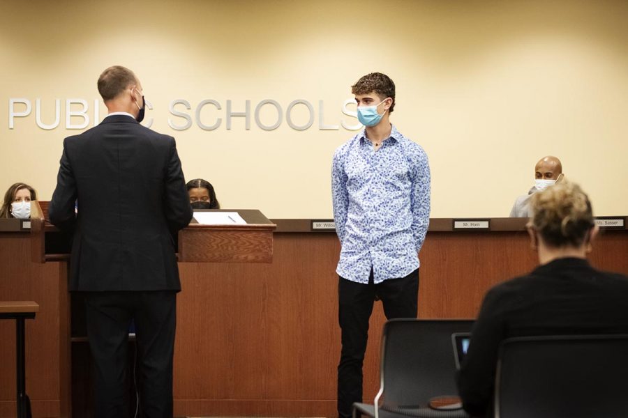 Principal Sirna presenting sophomore Andrew Hauser at the CPS board meeting Dec. 13. Hauser holds the record for the fastest cross country time of any high school student in Missouri history.