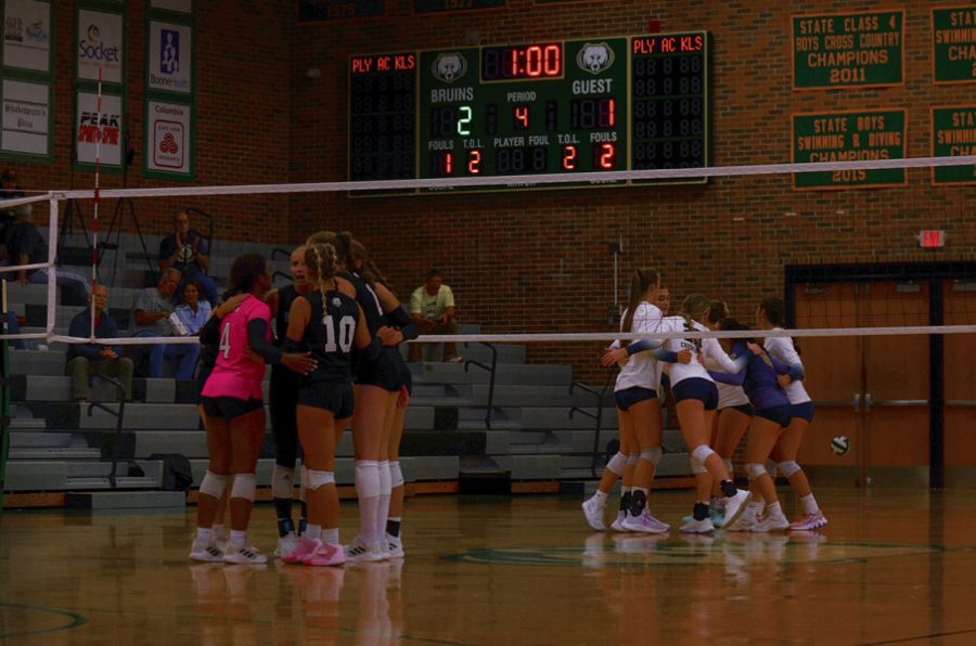RBHS and HCHS huddle with their teammates after RBHS scores a point during the fourth set. Photo by Bailey Blackburn.