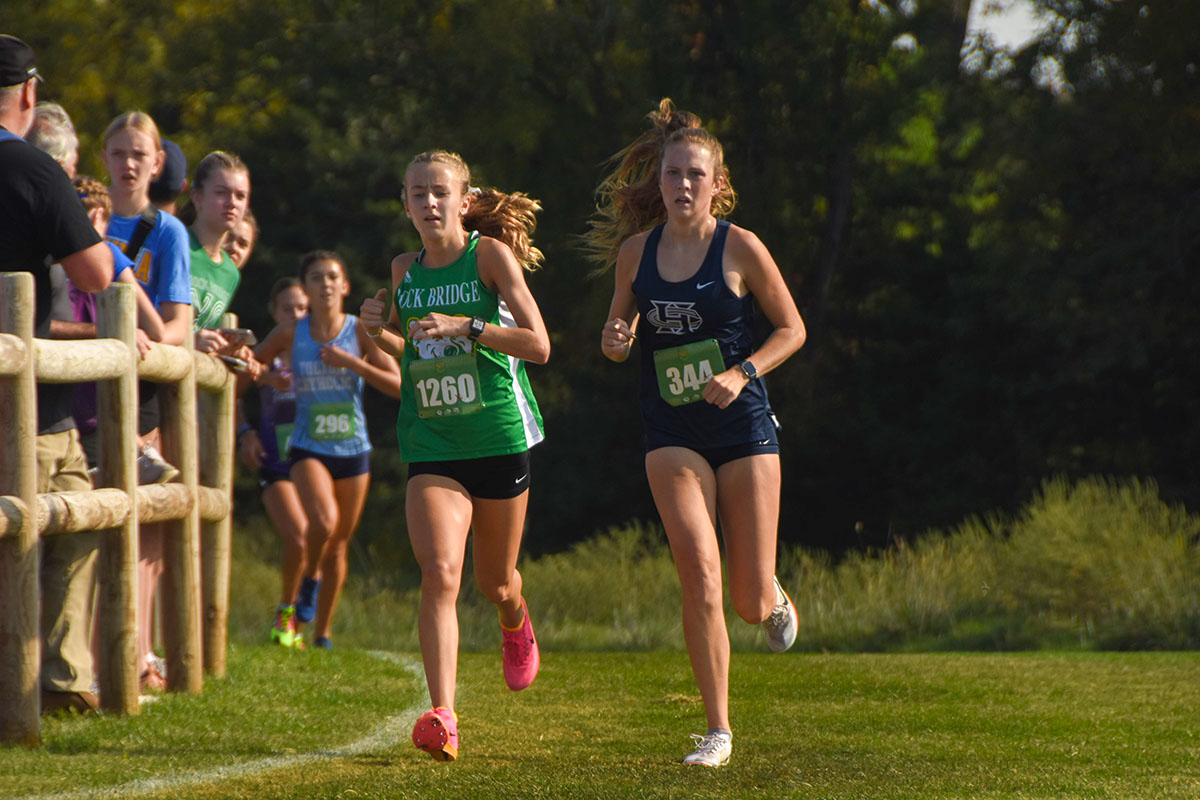 Claire Richardson (10) runs alongside Reese McDevitt from Francis Howell Central High School (11) at the Gans Creek Classic. 