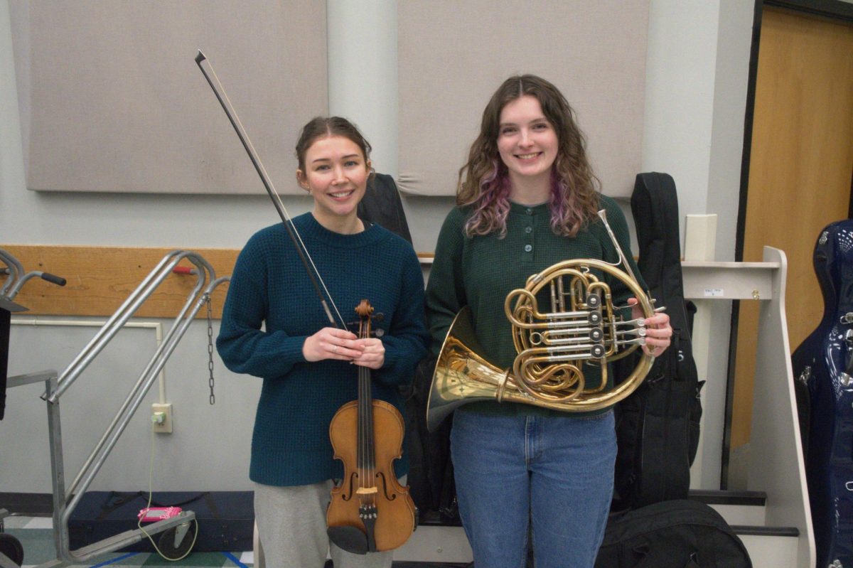 Hazel Keithahn (12) and Alexis Doeblin (12) hold up their instruments to be played at the 2024 All-State Orchestra. 