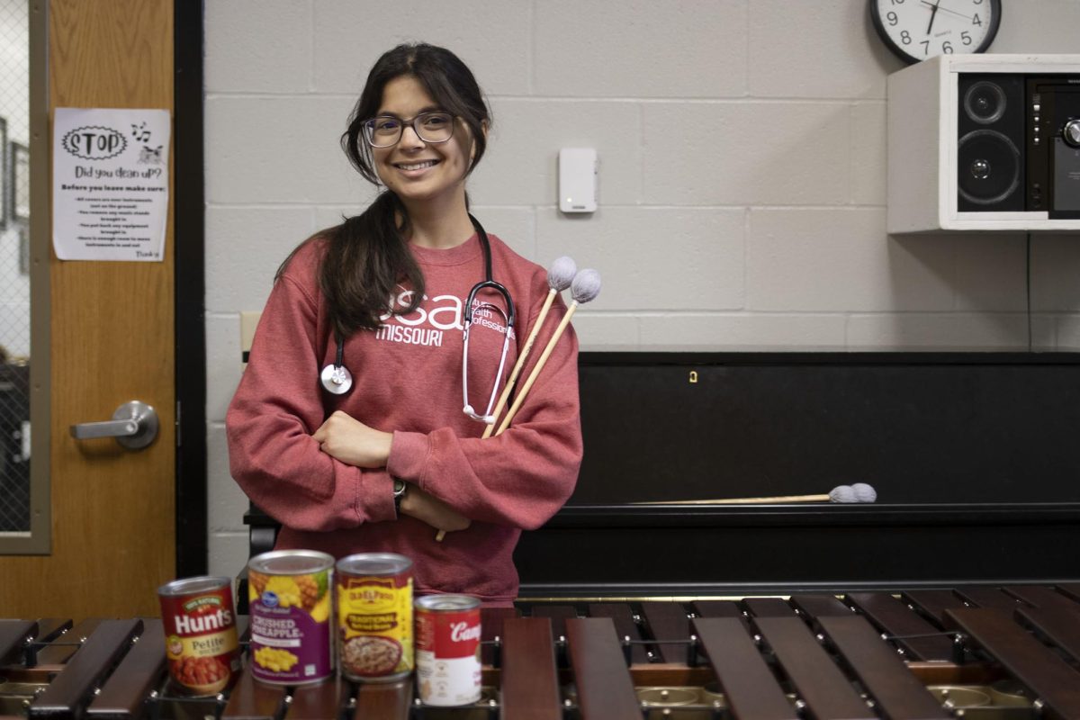 In the RBHS band room, Mira Tosh (12) poses with her mallets, stethoscope, and canned food. Tosh has developed many passions throughout her years of high school, including service and medicine. “I think [the most difficult thing] is just time management and stress, when there's all these clubs going on and then like tests, it can get overwhelming,” Tosh said. “But it's actually been kind of helpful because I know that I'm going to have overload in the future. It's important to kind of cope with it effectively and to avoid burnout.”