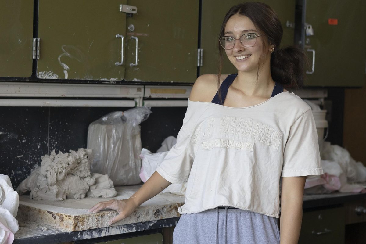 Standing in front of raw clay with nothing left untouched, Alexis Szydlowski (12) takes a break from prepping her clay after 3 years in this studio to take a senior photo. 